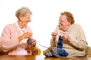 Two ladies laughing and knitting 